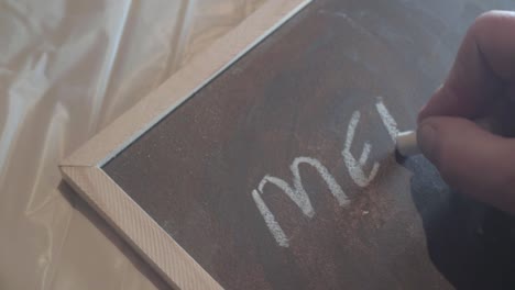 el dueño del café escribe el menú en una pizarra