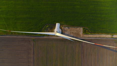 windmill producing alternative energy in field. wind tower creating eco power.