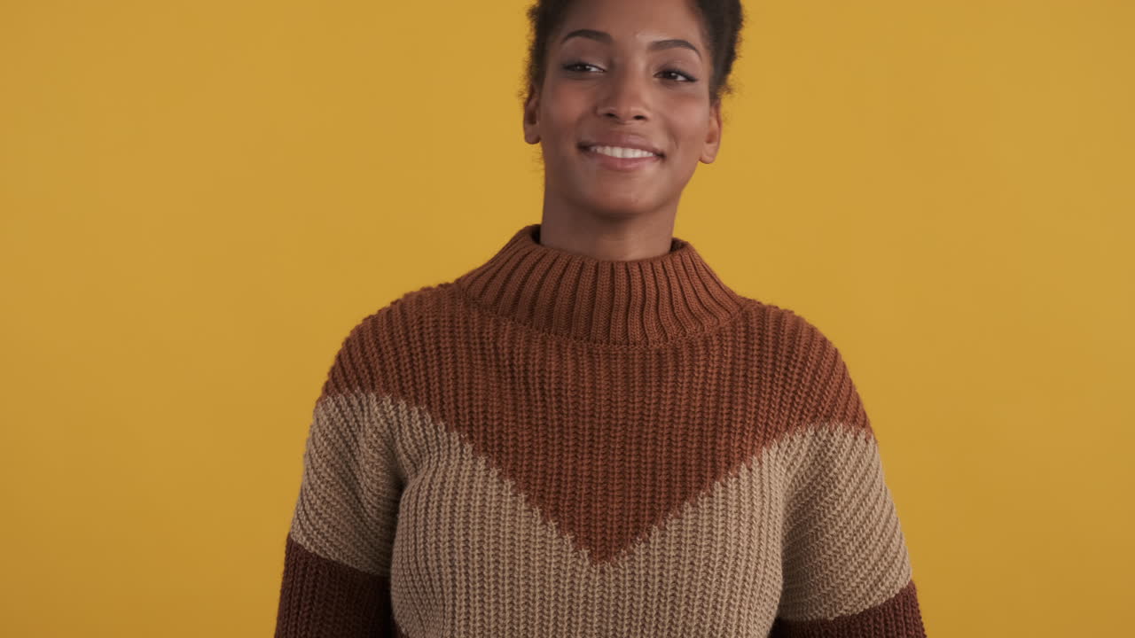 흑인 소녀가 승리의 표시를 하고 포즈를 취하고 있습니다.