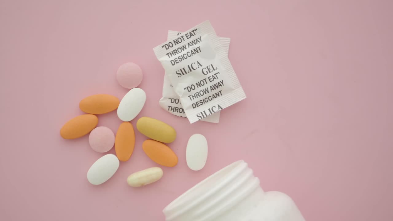 Pills and Silica Gel Packets on Pink Background