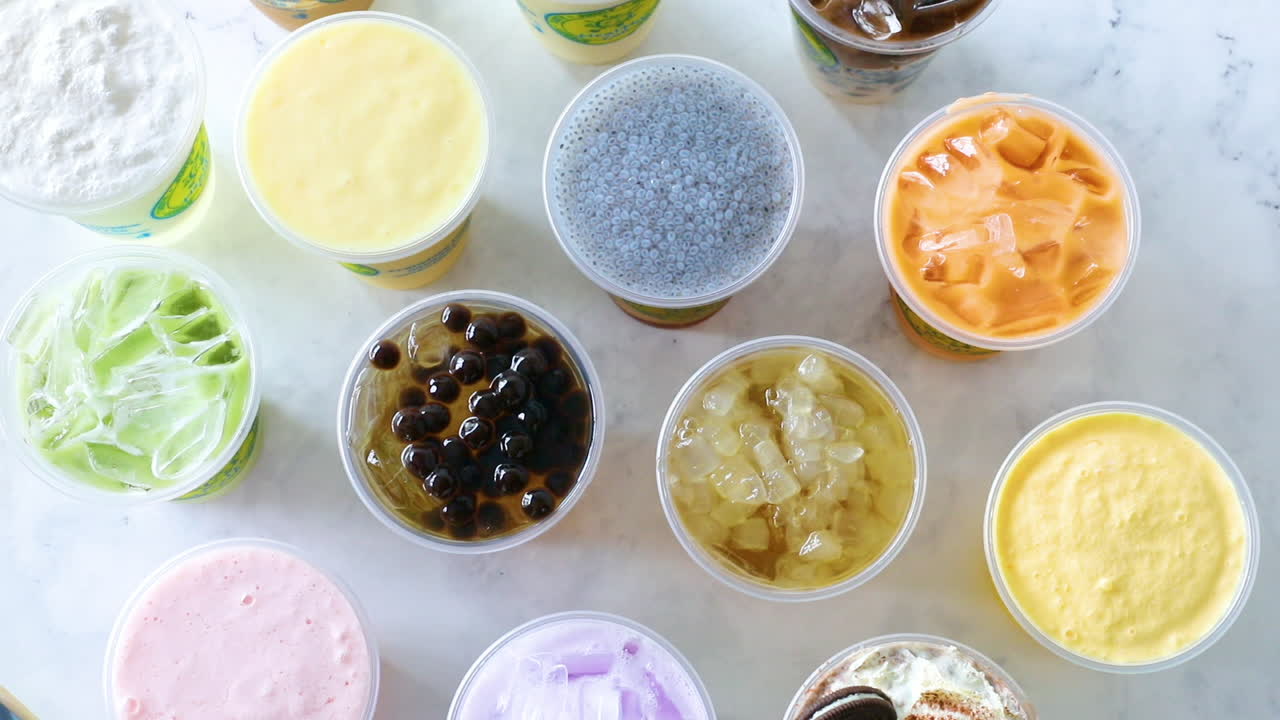 말차 그린 밀크티를 평평한 테이블 배치에 내려놓는 남성 손