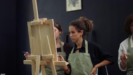 Estudiante-Y-Profesor-De-Arte-Durante-La-Lección-De-Pintura-De-Pie-Frente-Al-Caballete