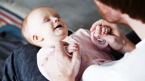 dad playing with joyful baby daughter