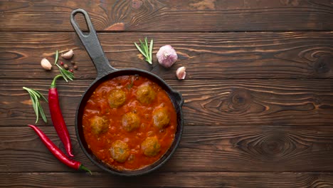 cocinar albóndigas con salsa de tomate en una sartén negra. colocación plana, vista superior con espacio de copia