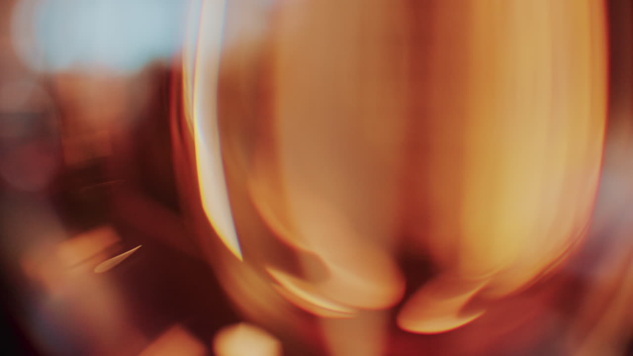 Artistic macro shot capturing warm glowing light streaks and blurry reflections through glass