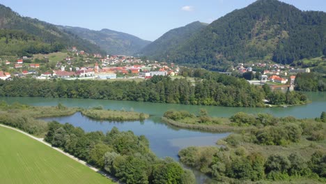 lush vegetation surrounding lake dravograd and rolling mountains