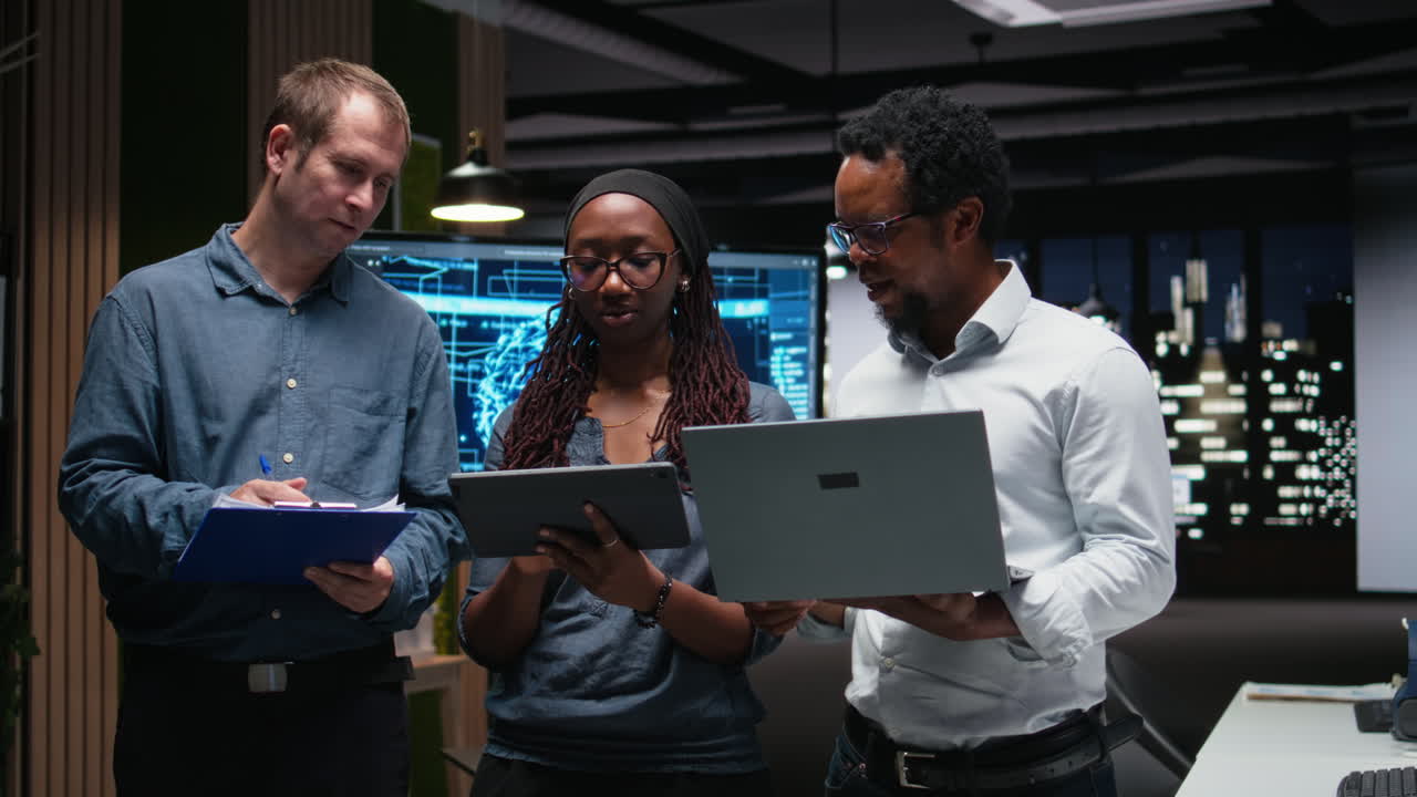 Diverse Business Team Collaborating with Laptop and Tablet in Modern Office