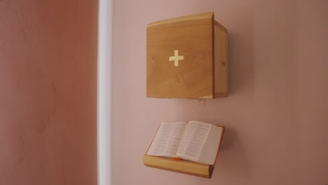 small wooden catholic church tabernacle with bible in small chapel on the wall