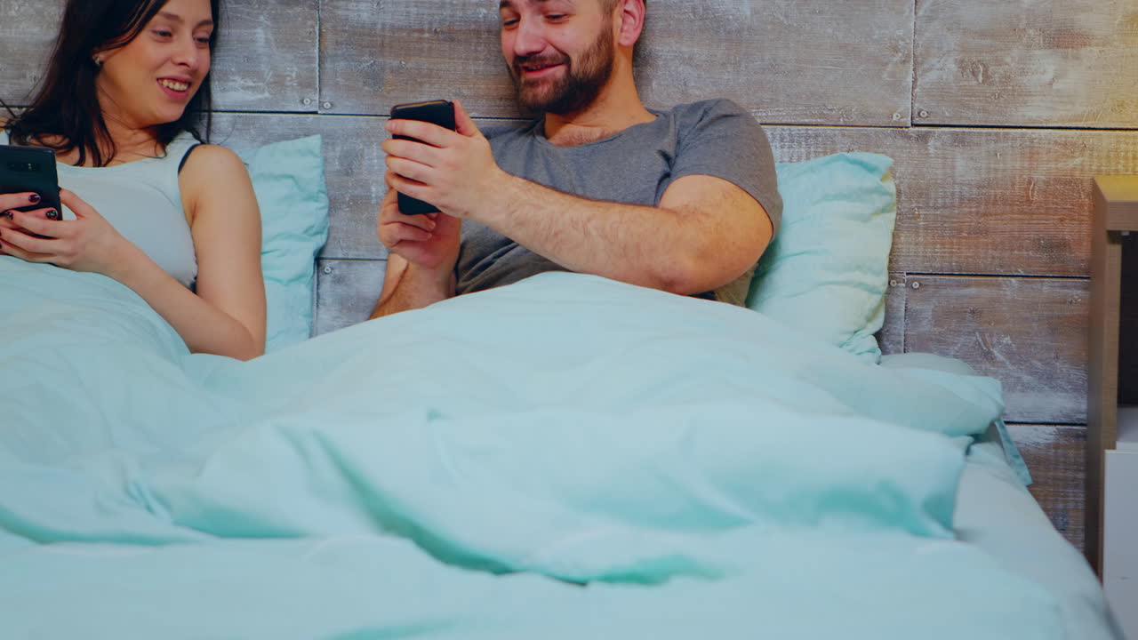 Cheerful young couple using smartphone