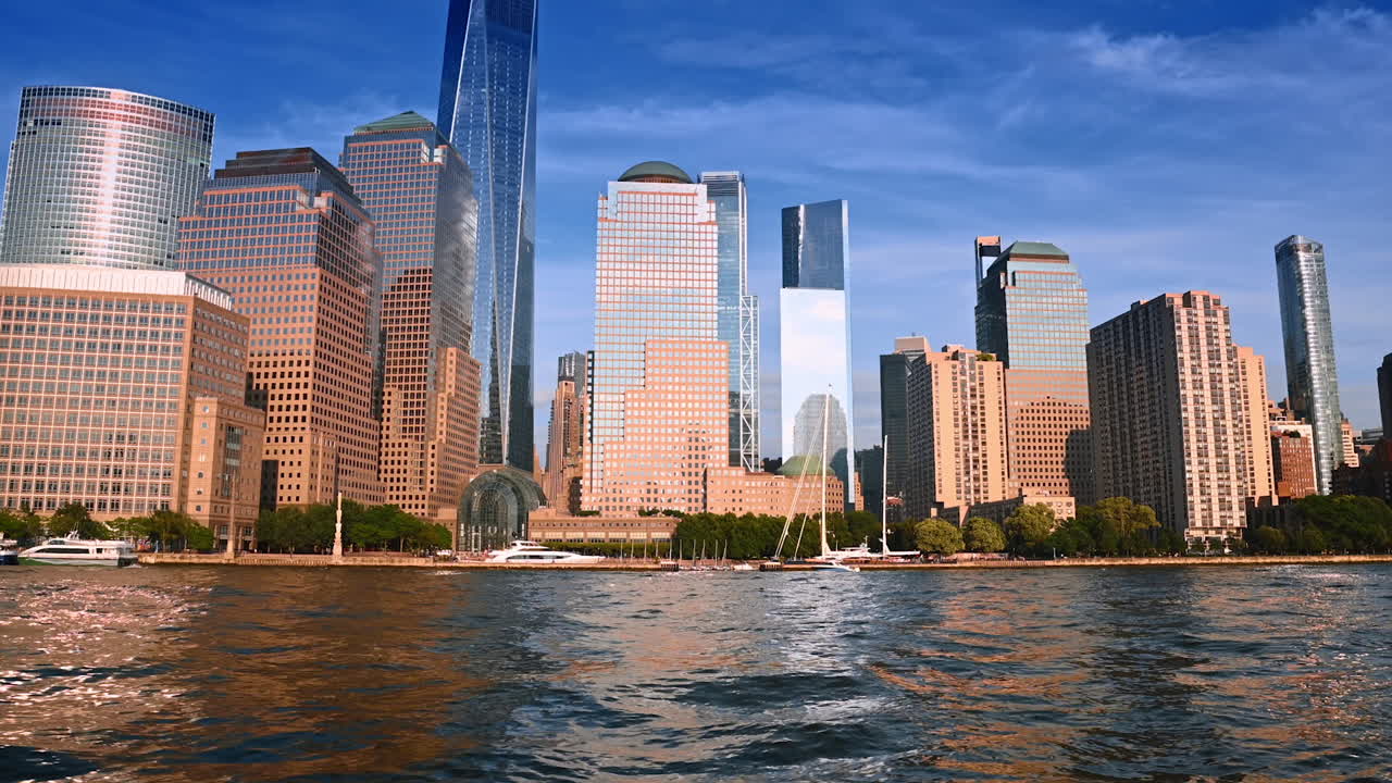 Bright sun lights the facades of the stunning buildings in New York skyline. Boat tour by the East River at daytime