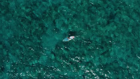 disparo aéreo de una persona en una tabla de remos en medio del océano