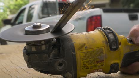 a contractor seen sharpening his chisel using a disc grinder