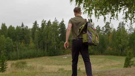 Disc-golfer-steps-onto-the-tee-and-puts-bag-down---Full-shot