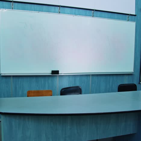 presidium place with modern equipment. auditorium with a blackboard, white board and teacher's table. beautiful empty classroom in blue colors