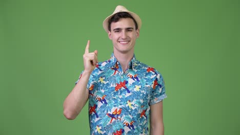 Young handsome tourist man thinking while pointing finger up