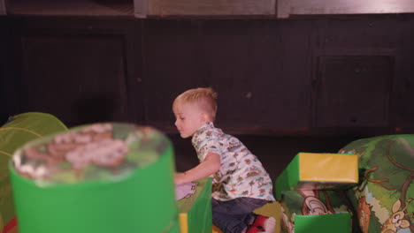 young boy happy child playing happily on soft play set