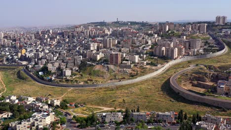 an aerial view of a city divided by a large security barrier