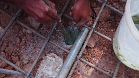 construction worker filling chemical in rock hole and inserting rebar to support footing for building strength at construction site. day time, stable shot, close-up shot, 4k