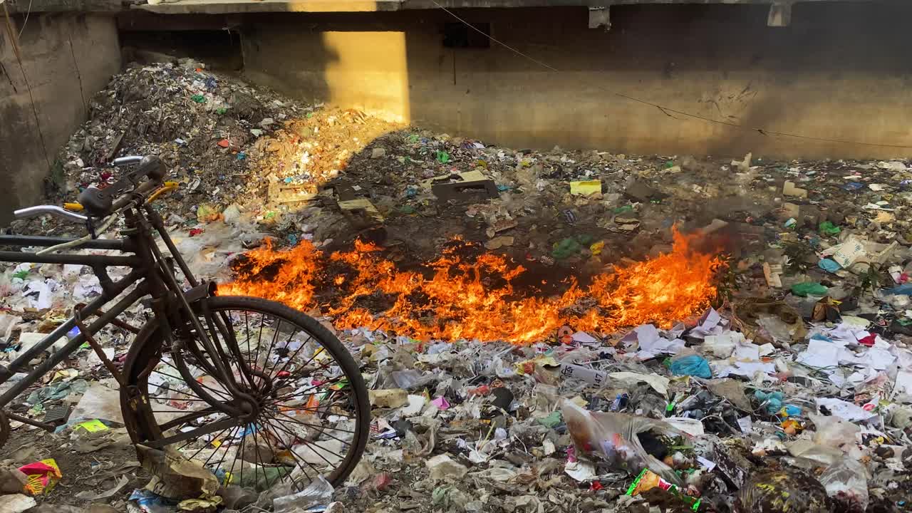 vertedero lleno de basura ardiendo con llamas naranjas en dhaka