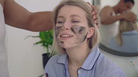 portrait of a female having a dark facial mask applied