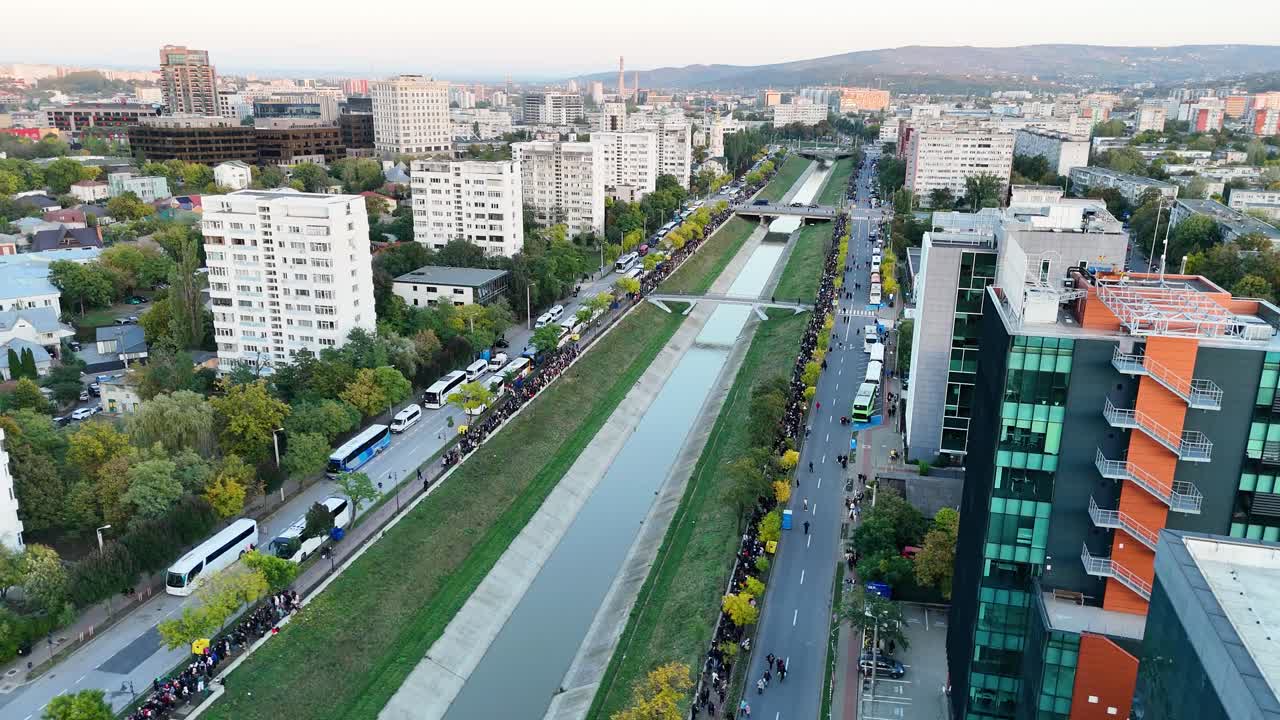 Aerial drone shot over Iasi, Romania, showing the Bahlui River and long lines of pilgrims heading toward the Metropolitan Cathedral during the Saint Parascheva celebration