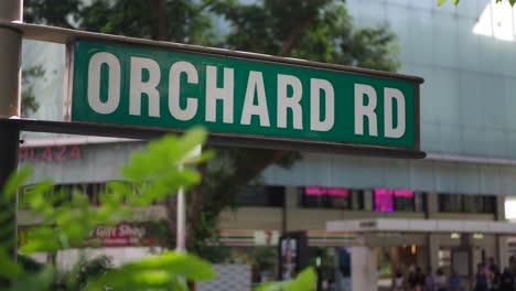 orchard road street sign with city background