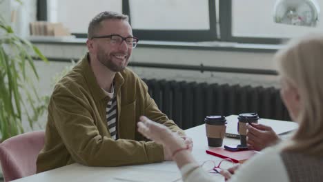 businessman having discussion with colleagues at meeting table in office