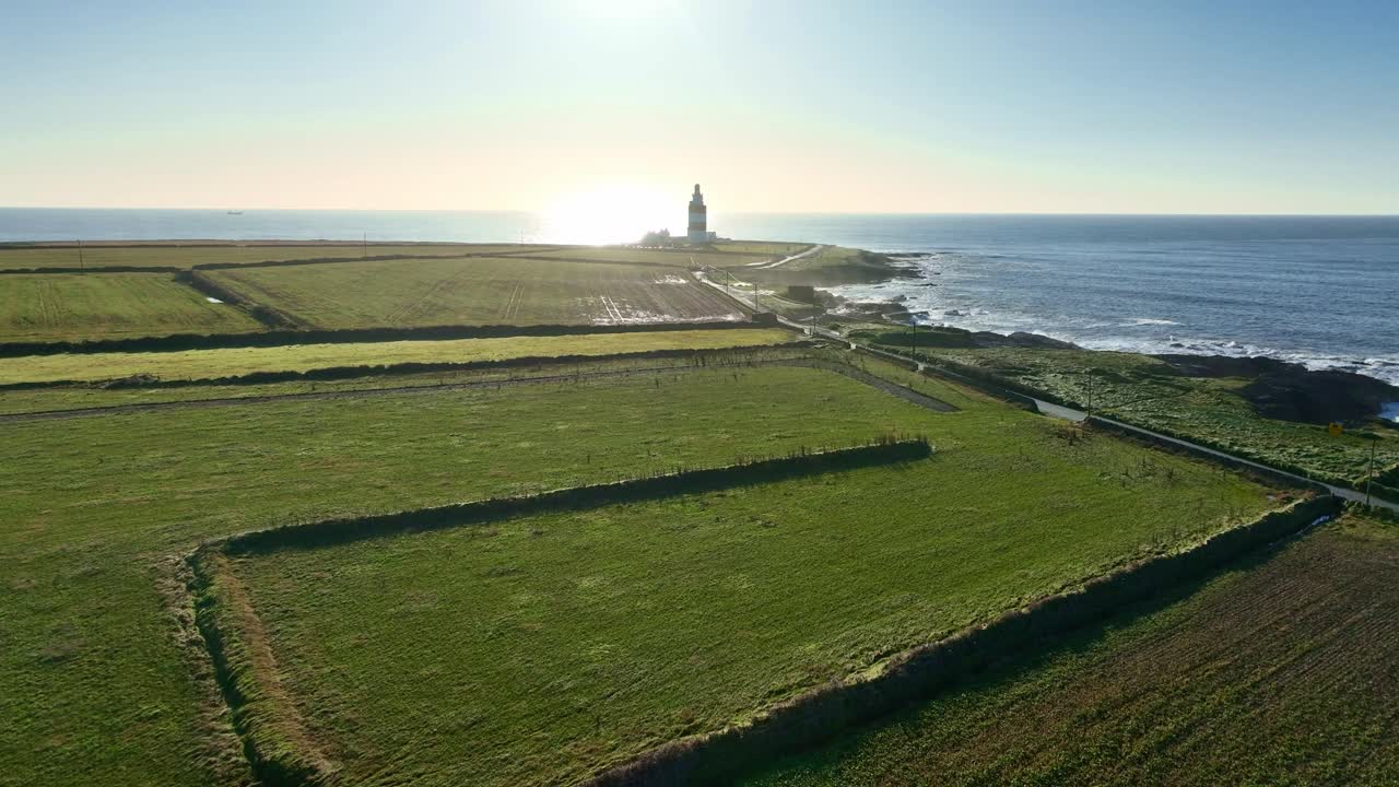 Flyger lågt med drönare över Hook Head-halvöns vinterjordbruksmark till fyren, episka irländska landskap
