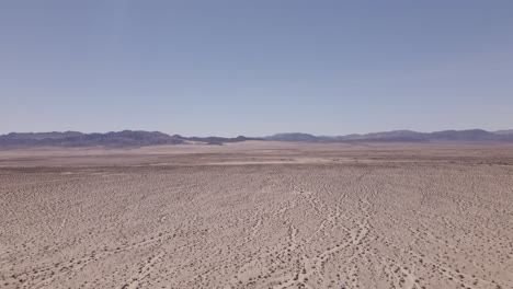 high, slow push drone shot of a vast desert landscape near joshua tree in the early afternoon