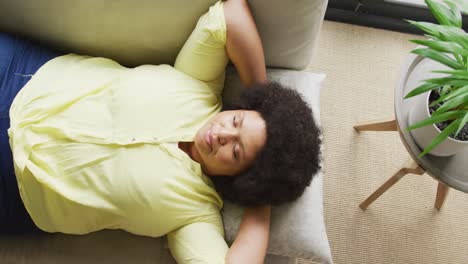 Video-of-plus-size-african-american-woman-relaxing-on-sofa