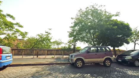 vehicles moving along a cobblestone street