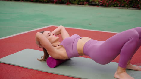 mujer haciendo ejercicios de rodadura de espuma al aire libre