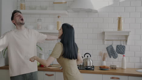una pareja divirtiéndose en la cocina.