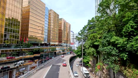 traffic flows beside golden buildings and greenery