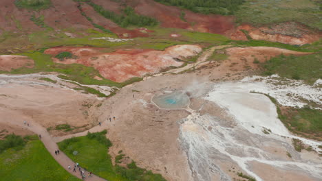 Aerial-view-of-strokkur-geyser,-touristic-attraction-of-Golden-Circle-in-Iceland.-Drone-view-of-most-famous-geyser-in-Iceland,-in-geysir-valley,-with-tourist-waiting-for-eruption.-Strokkur-geyser