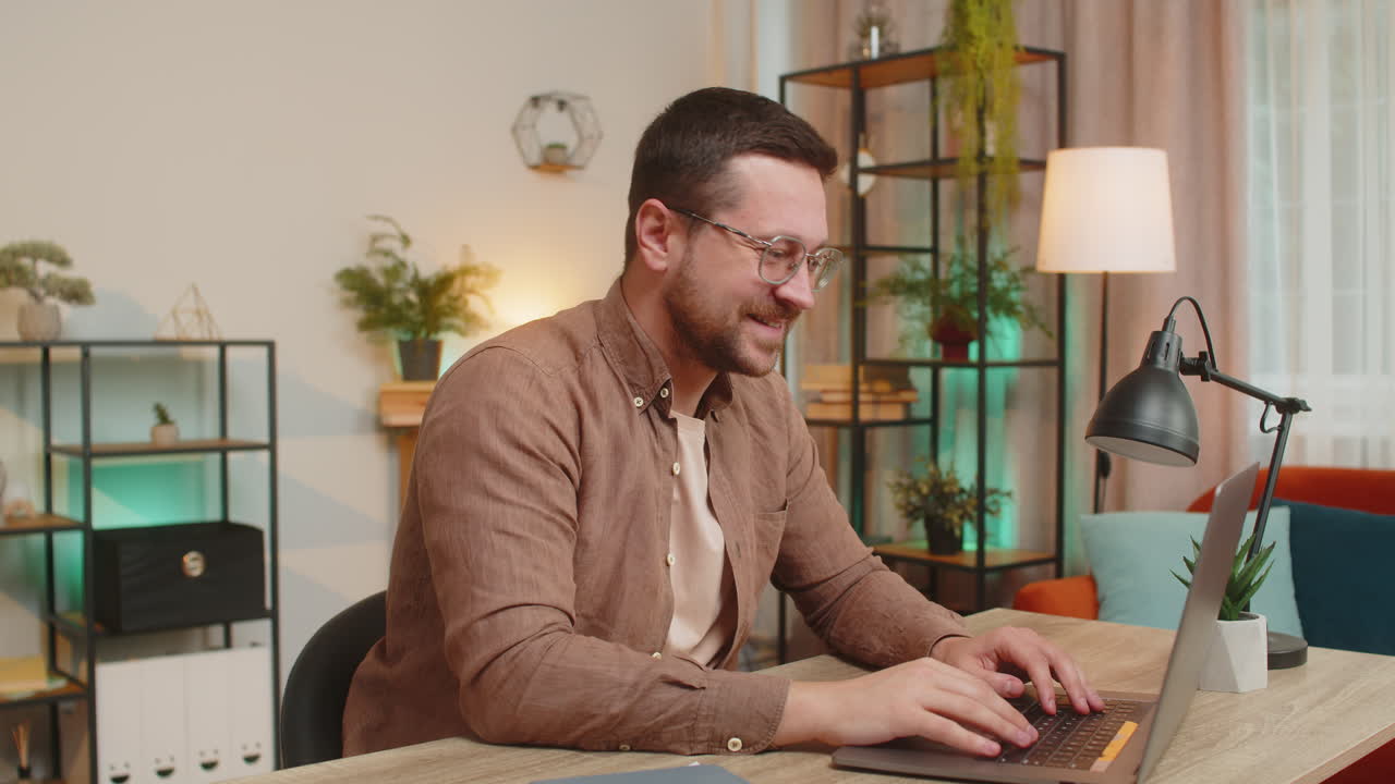 Happy caucasian businessman employee using laptop and waves hand hi gesture greeting at camera