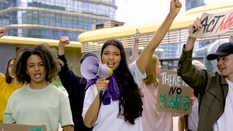 girl holding megaphone next to her colleagues, protesting about pollution