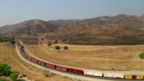 Tren-Moviéndose-Lentamente-A-Lo-Largo-De-Las-Vías-Debajo-De-Una-Quema-De-Incendios-Forestales-Extinguida-Cerca-De-Caliente,-California