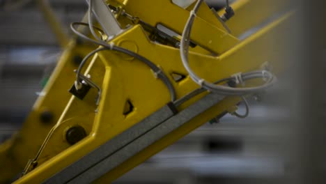 Blurred image of yellow industrial machinery with cables and metal components
