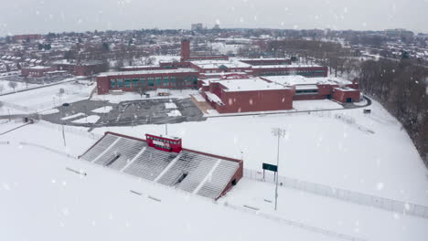 winter snow falls at school, college university campus athletic fields