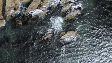 imágenes de drones a vista de pájaro de olas rompiendo en las rocas