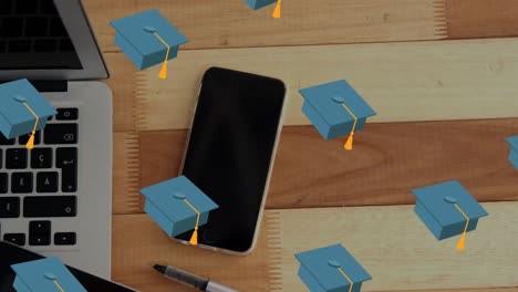 Animation-of-falling-hats-over-laptop-on-desk