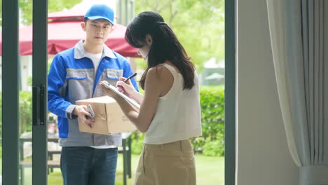 delivery man uniform smiles during express, courier holding a small package parcel delivering goods to customer's home with van truck, door-to-door services