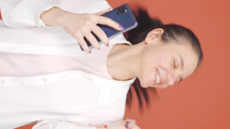 手に携帯電話を持った踊る女性の垂直ビデオ ⁇