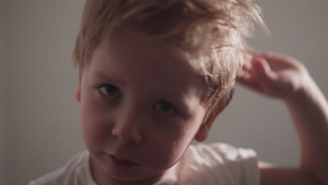 un niño impotente limpia el sudor de la frente con la mano.