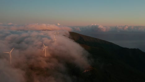 aerial of mountainous windmill park with thick mist flowing through, madeira