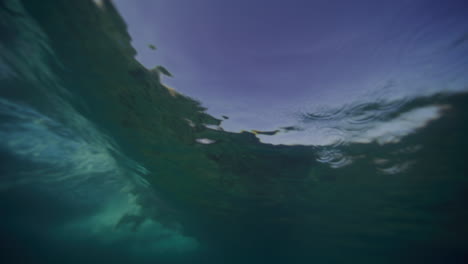 underwater hazy view of breaking wave crashing on surface