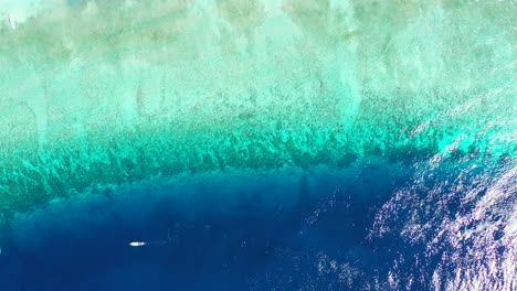 the sun glistening against the crystal clear waters off the coastline of the popular tourist destination of the maldives