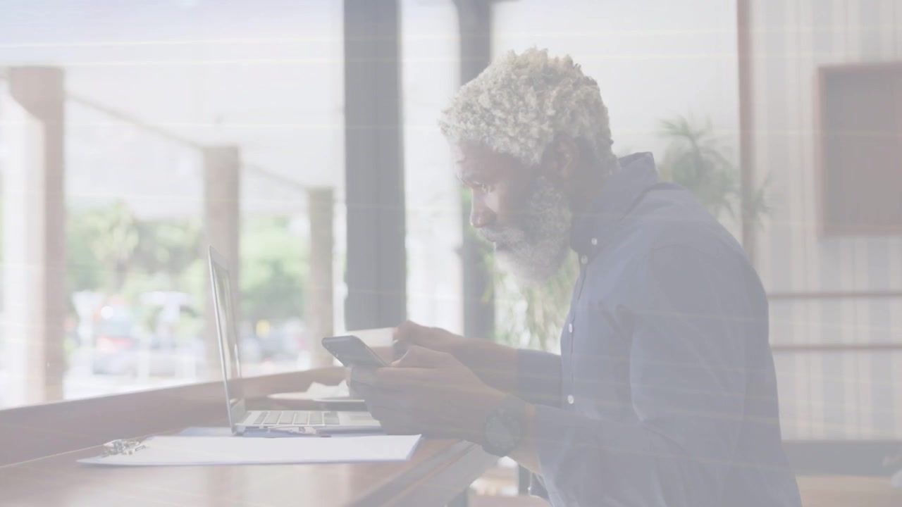 Man sipping mug, glancing laptop then picking phone, reading as animated overlay showing biz data