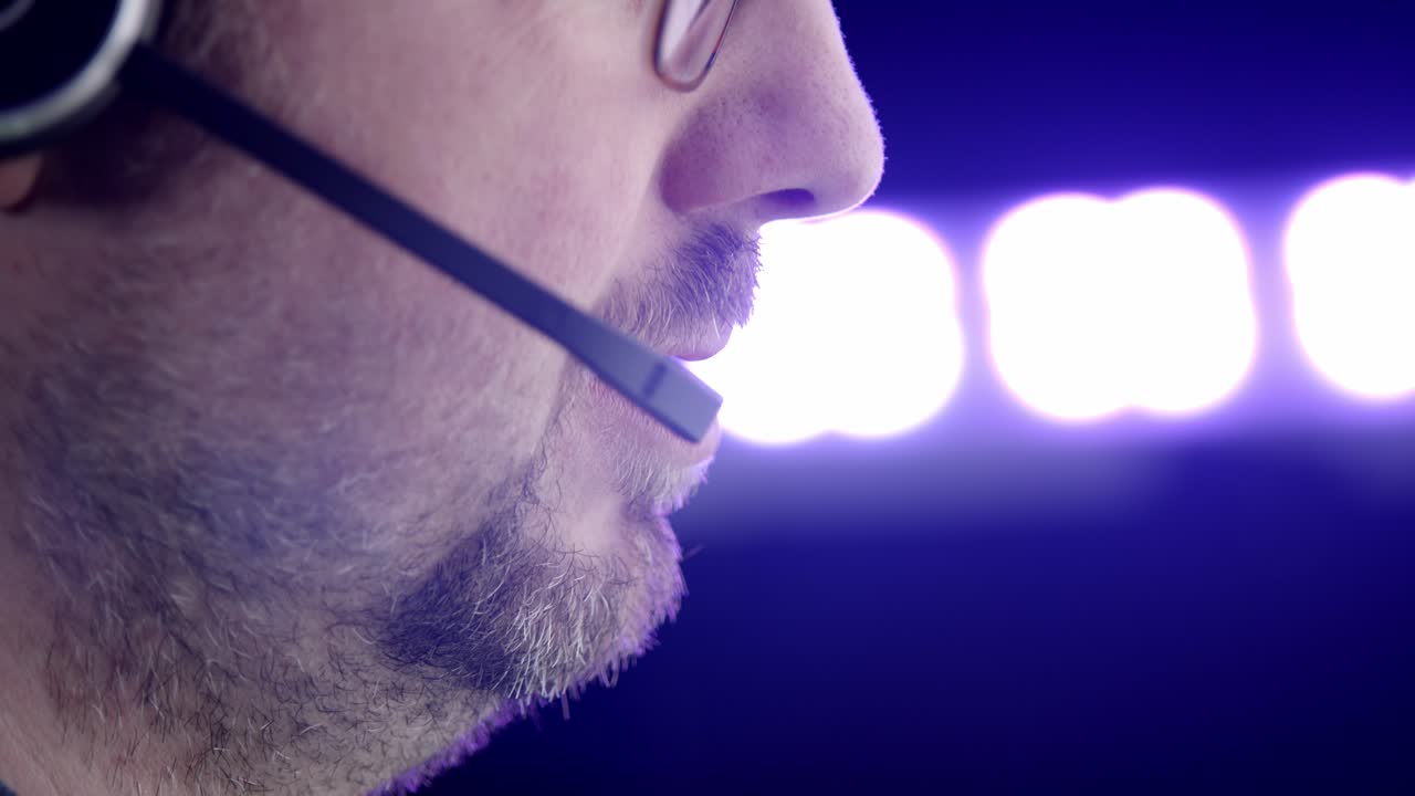 Skjeggete hvit mann i profil snakker i telefonhodesett med en klient.